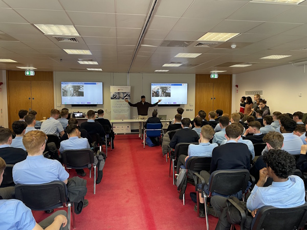 An engineering researcher talks to a room of secondary school students